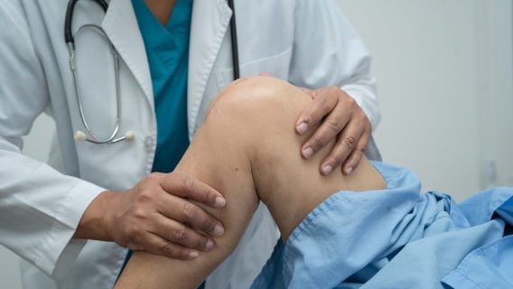 Doctor examining knee