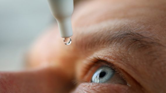 man using eye drops