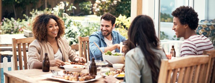 Group of friends enjoy dinner at a table outside