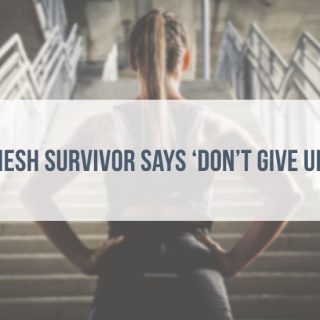 Woman staring up at a staircase standing with her hands on her hips