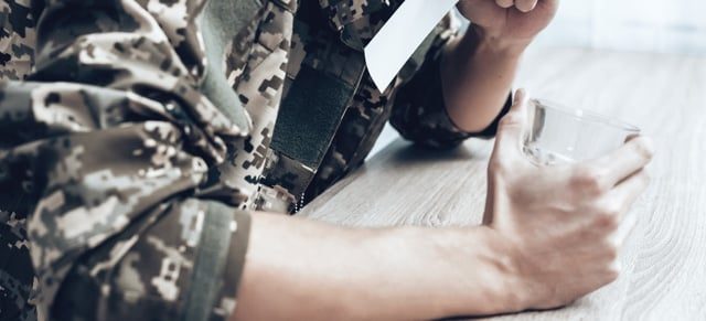 Army soldier hold a glass of alcohol