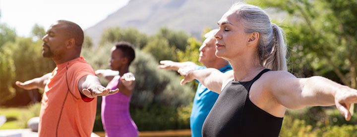 Adults doing yoga outside