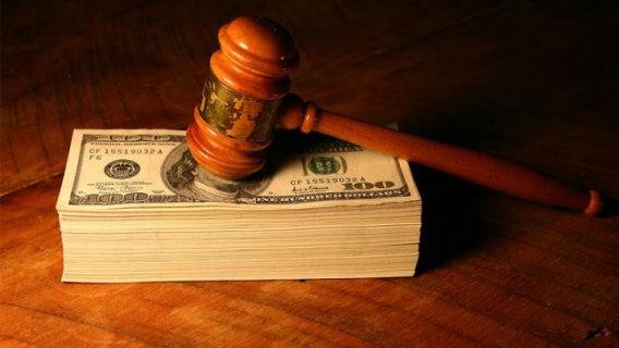 gavel resting on a stack of hundred dollar bills