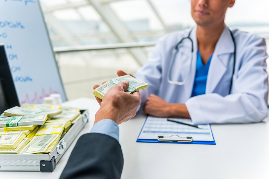 businessman bribing doctor with a suitcase full of money