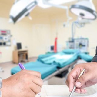 signing a document with medical device equipment in the background