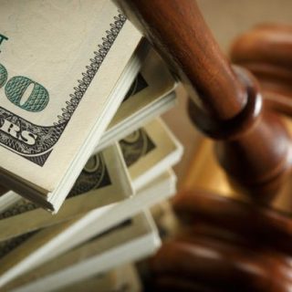 stack of hundred dollar bills and a gavel