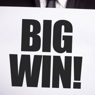 Man in suit holding a paper that read 