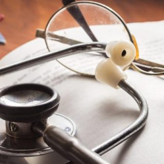 stethoscope and glasses resting on a book