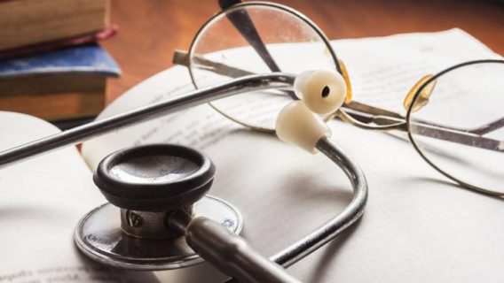 stethoscope and glasses resting on a book