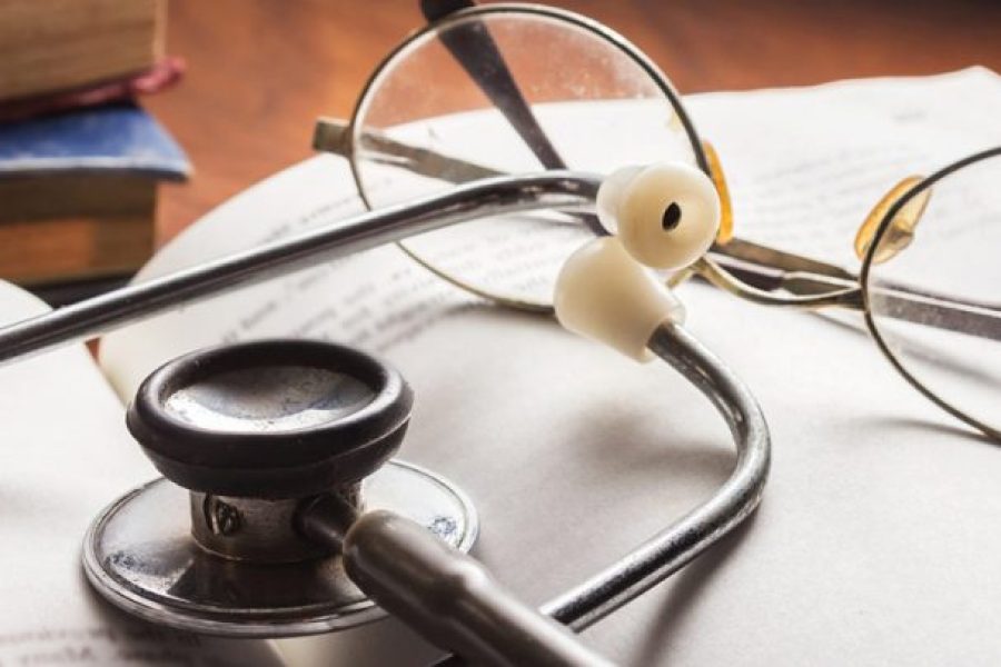 stethoscope and glasses resting on a book