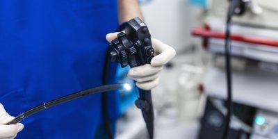 Doctor holding endoscope before gastroscopy medical examination.