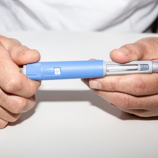 Person holding Ozempic insulin injection pen