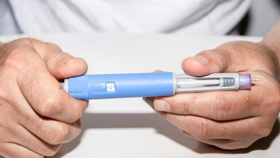 Person holding Ozempic insulin injection pen