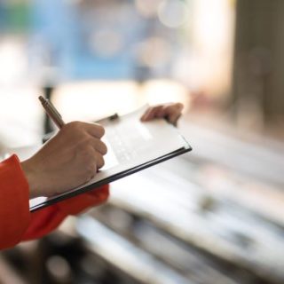 Inspector in orange holding clipboard