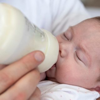 Preemie baby being fed with bottle