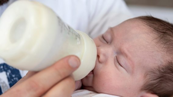 Preemie baby being fed with bottle