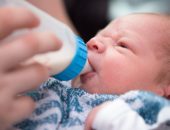 Newborn infant drinking from bottle