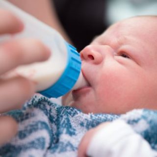 Newborn infant drinking from bottle