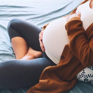 Pregnant woman cradling her abdomen