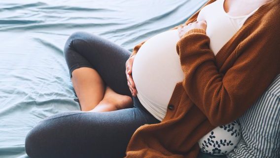 Pregnant woman cradling her abdomen