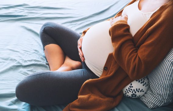 Pregnant woman cradling her abdomen