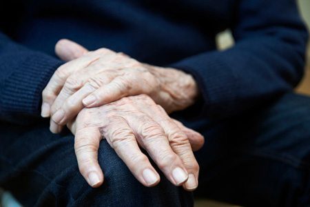 Elderly Person's Wrinkled Hands on Lap
