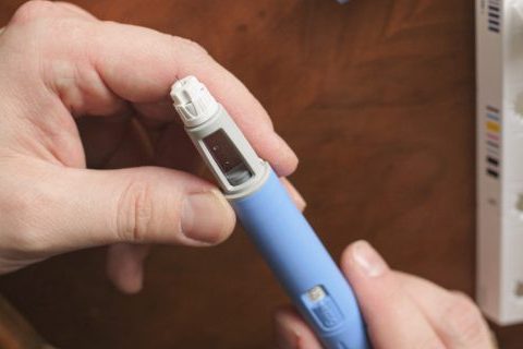 Man holding blue semaglutide pen