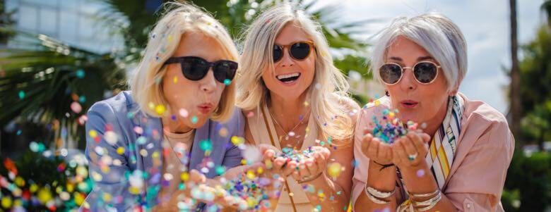 elderly ladies blowing confetti