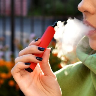 Girl smoking red e-cigarette