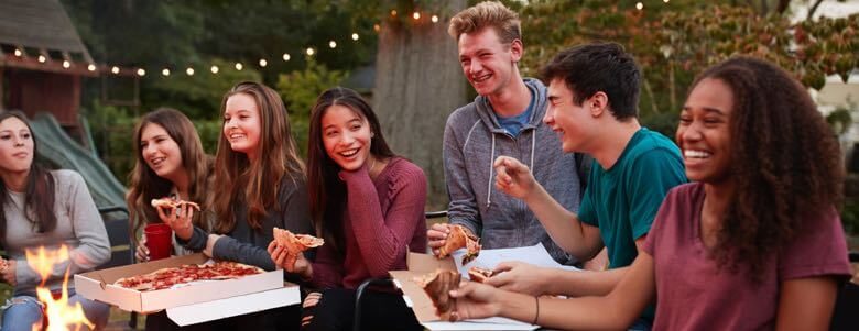 teens outside eating pizza