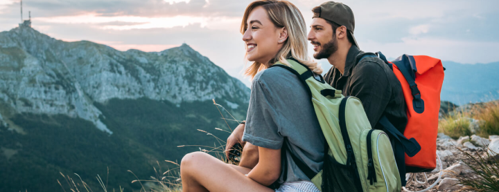 Woman and man sitting on top of mountain