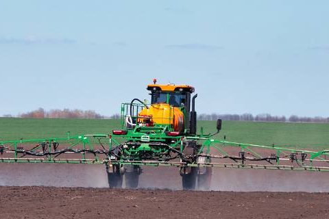 Tractor spraying fields