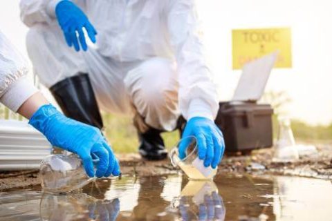 Workers in hazmat suits testing water