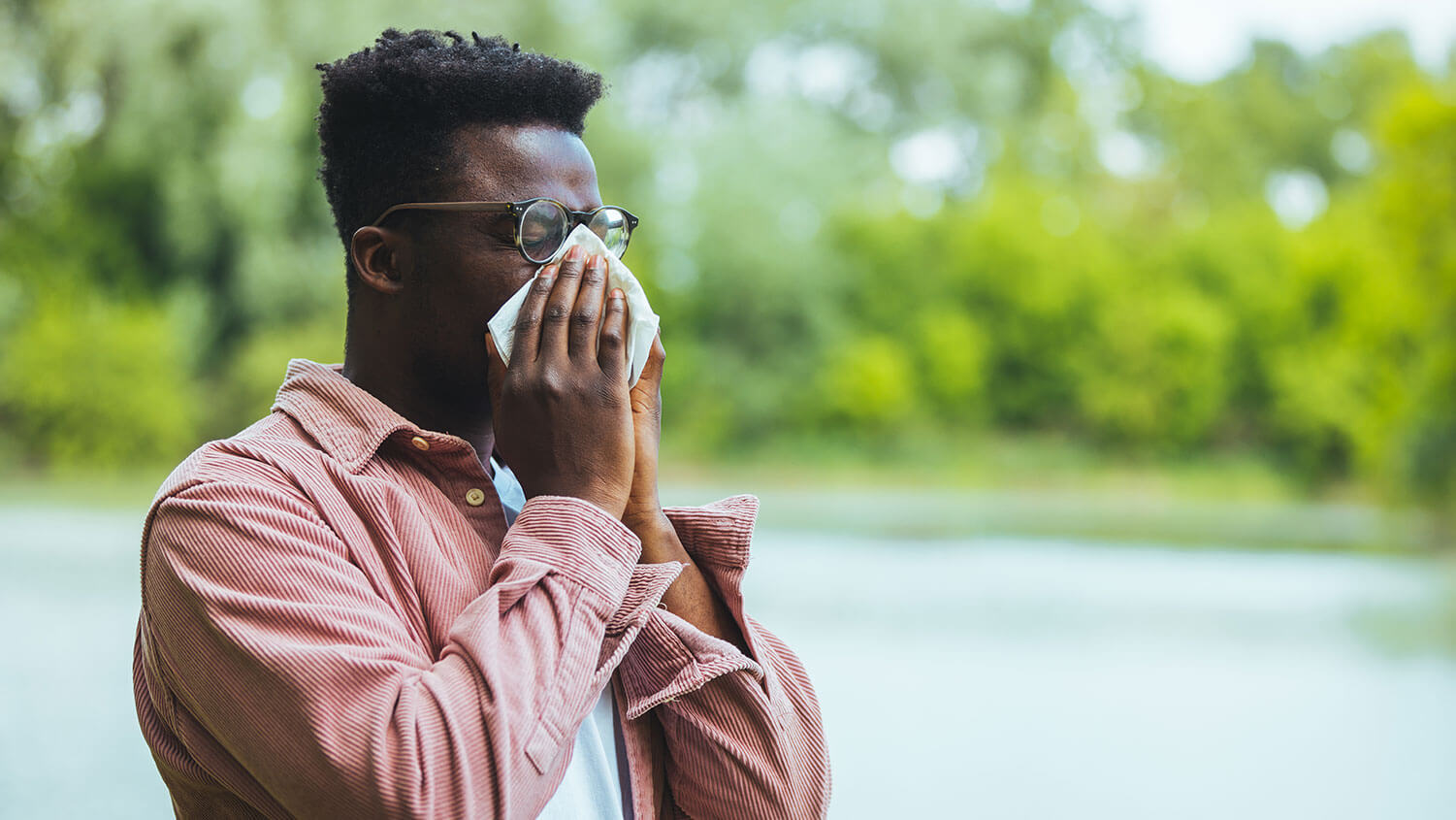 A man sneezing into a tissue.