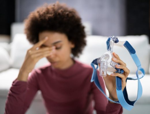 Shocked Young Woman Holding CPAP Machine Mask