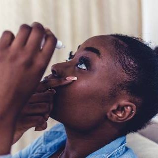 Woman putting in eye drops