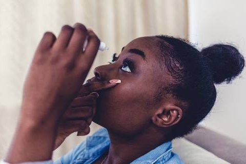 Woman putting in eye drops