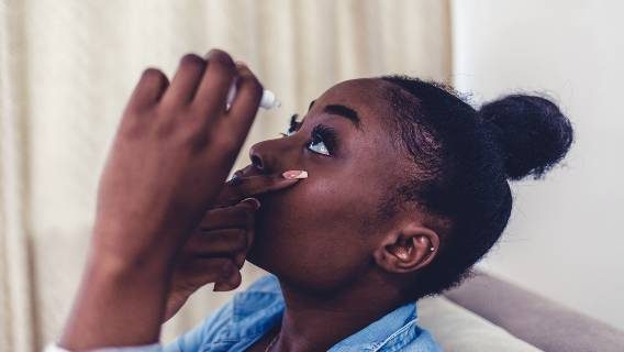 Woman putting in eye drops