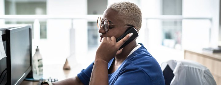 Hospital receptionist speaking to someone on the phone