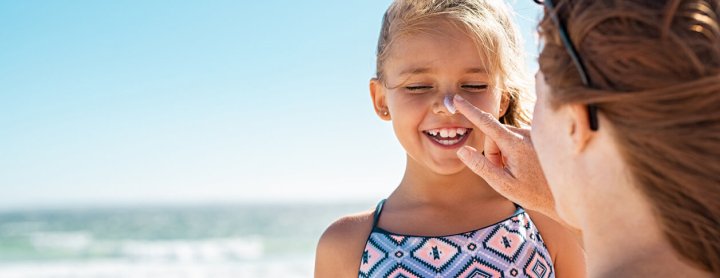 Woman putting sunscreen on child's face