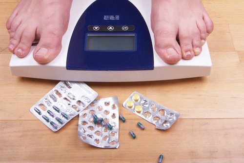 feet on scale and pills on the floor feet on scale and pills on the floor