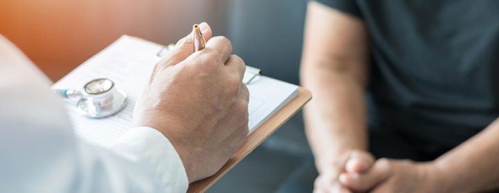 Doctor taking notes on a patient