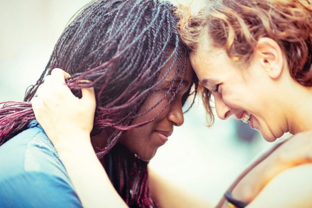 Black woman and white woman embracing each other lovingly