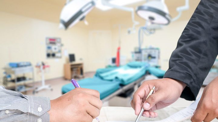 news-medical-device-modifications-approved-with-poor-data-report signing a document with medical device equipment in the background
