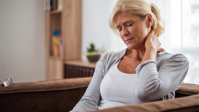 woman holding her neck in pain